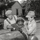 Elmer Thomas and his son top off the radiator before setting out. (Shorpy)
